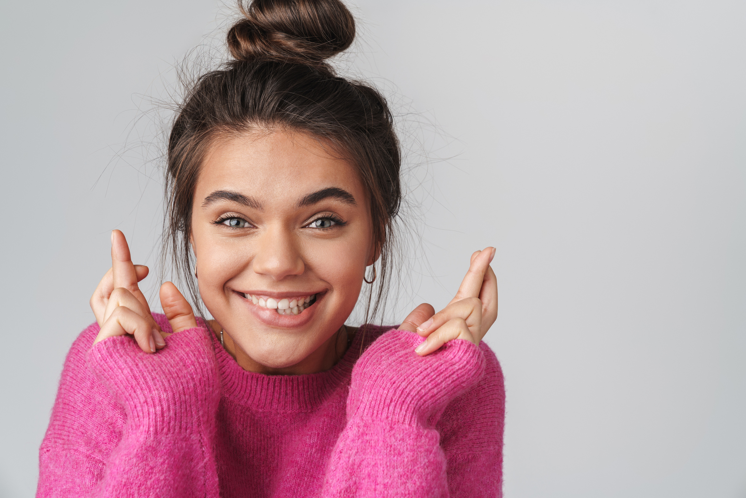 Woman Smiling with Fingers Crossed